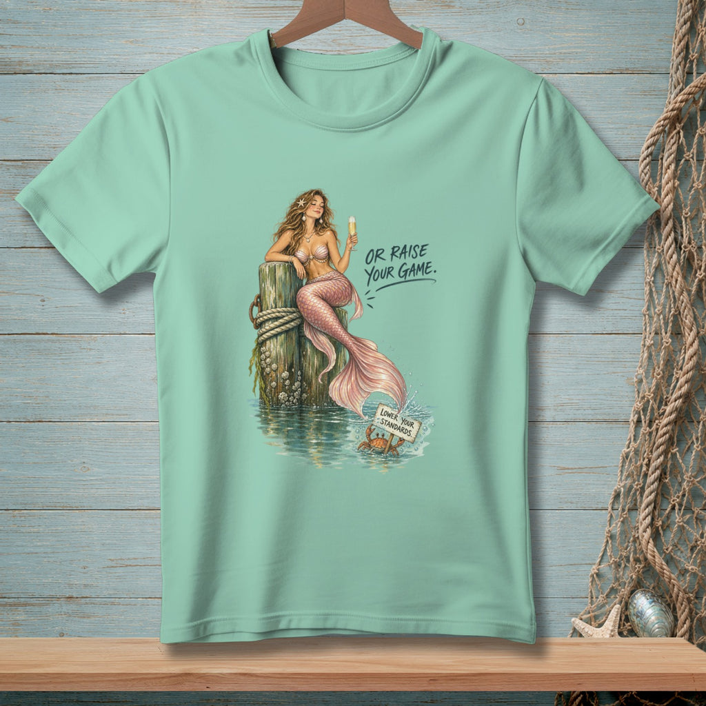 Mint t-shirt with mermaid on post and crab holding sign saying "Lower Your Standards."