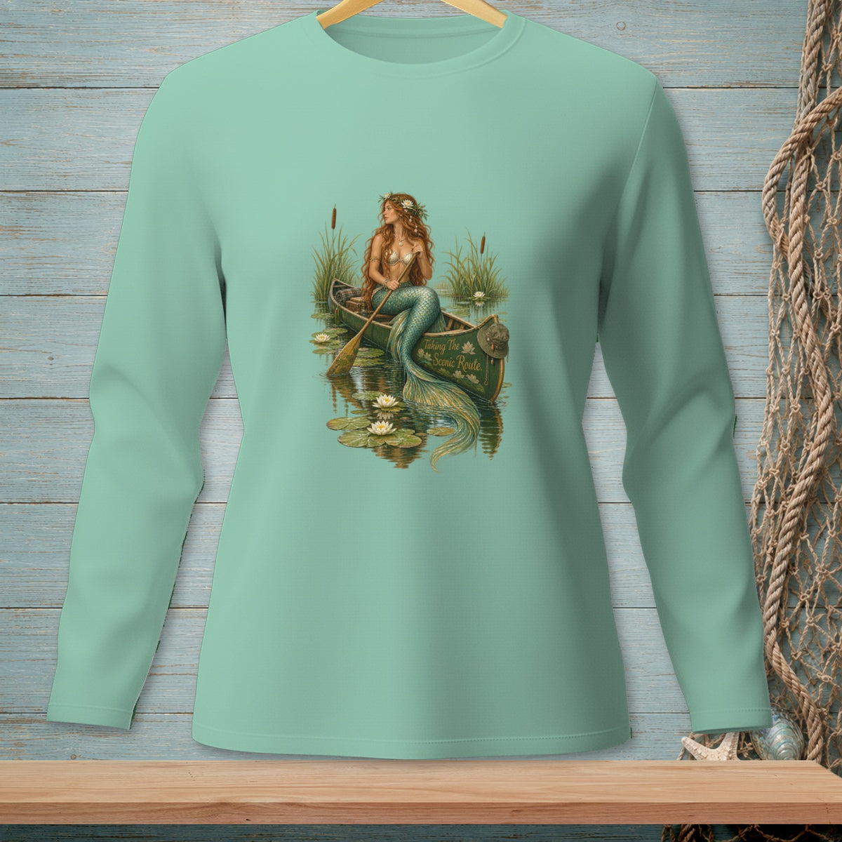 Mermaid in a canoe with water lilies and reeds, text "Taking The Scenic Route."
