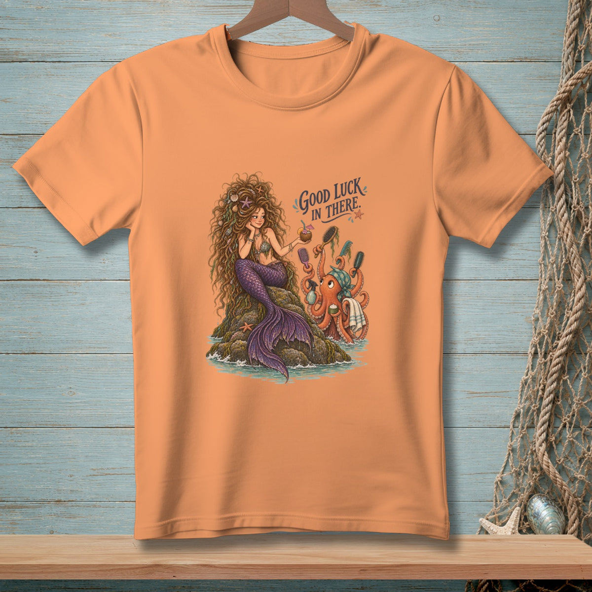 Mermaid and octopus illustration with "Good Luck In There" text on an orange t-shirt.