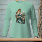 Mermaid sitting on a dock, writing in a book, with sailboats in the background.