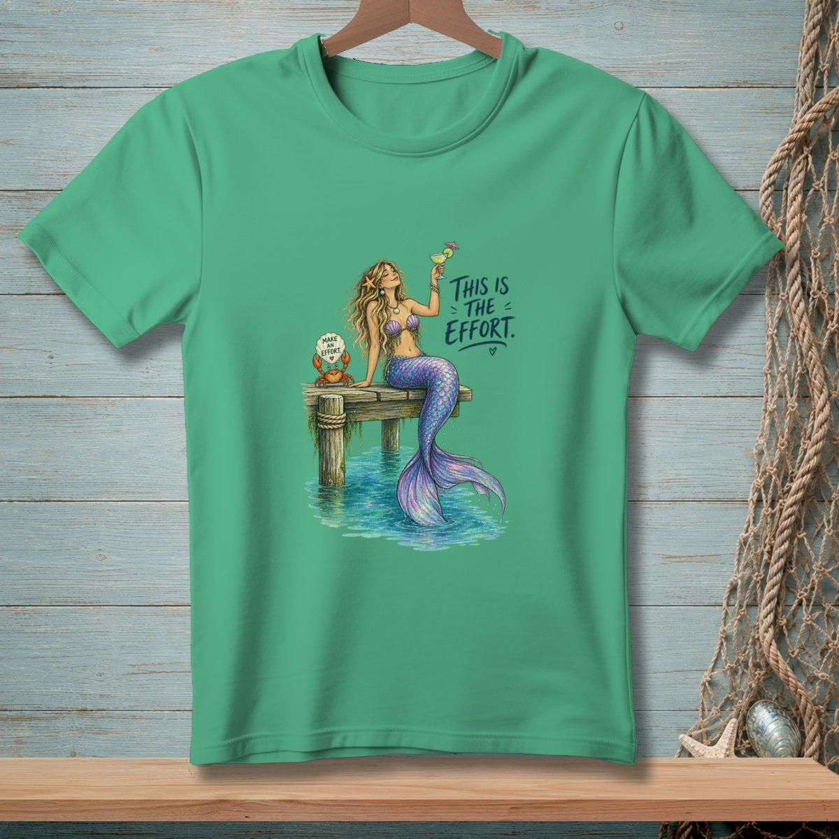 Green t-shirt with illustration of a mermaid holding a drink and text "This is the effort."