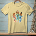 Three mermaids with colorful tails sit and drink cocktails together.
