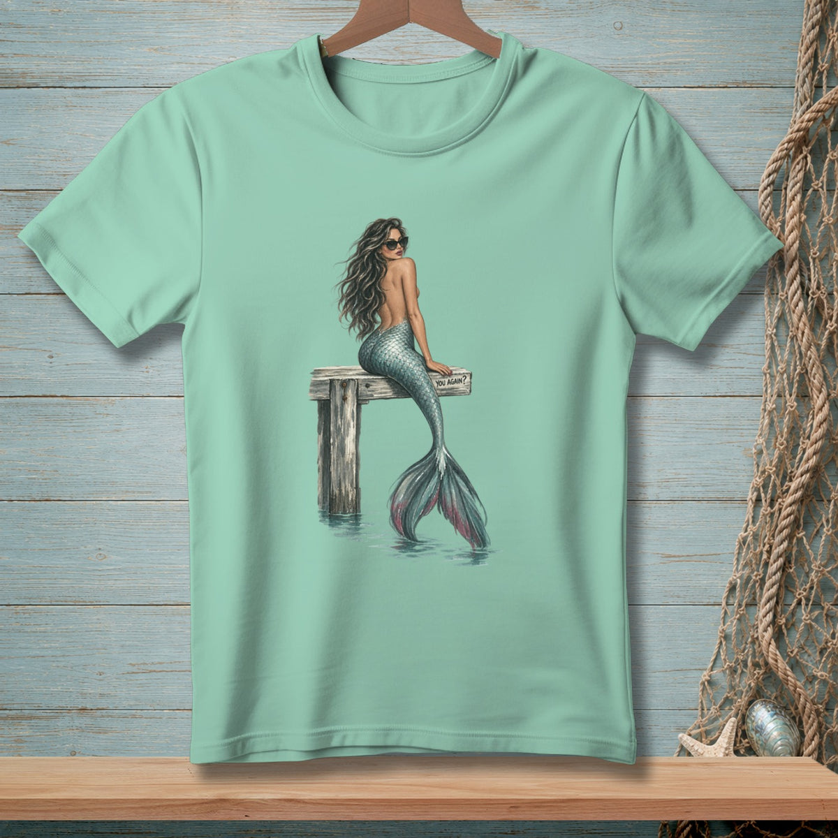 Mint t-shirt with a mermaid sitting on a pier, wearing sunglasses and a sign saying "YOU AGAIN?".