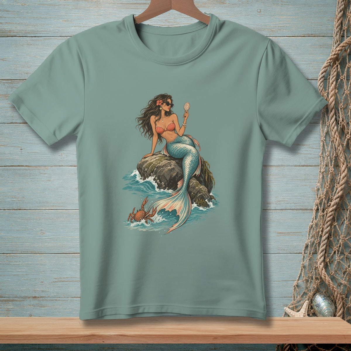 Mermaid with sunglasses sitting on rock holding shell, crab in waves.