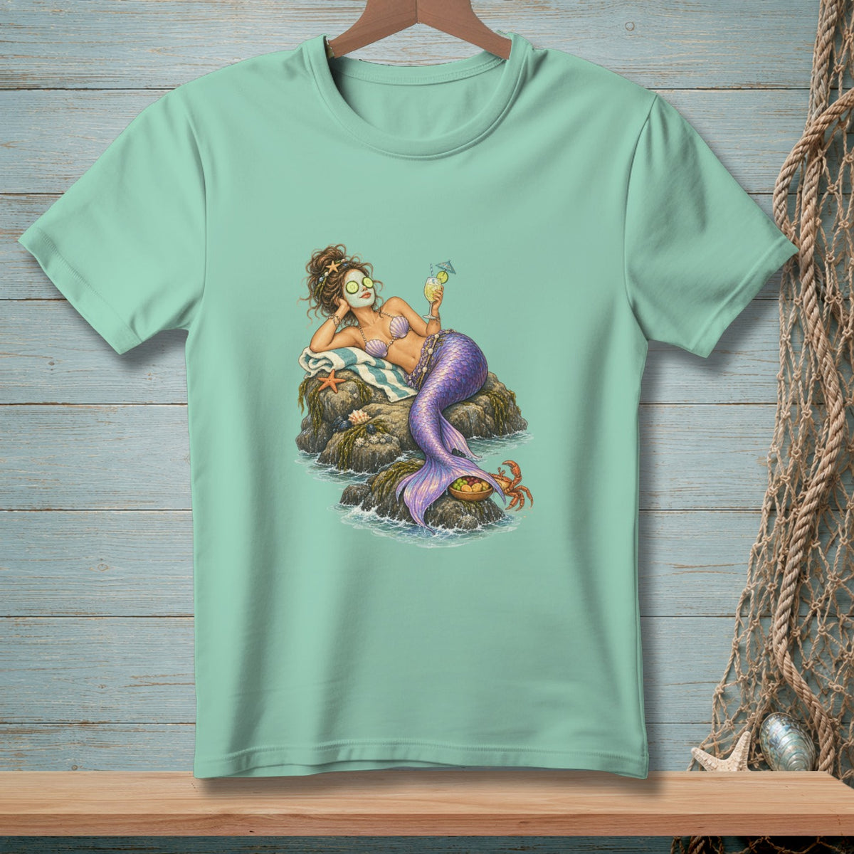 Mermaid relaxing on rocks with a drink, wearing eye patches and a seashell bikini.