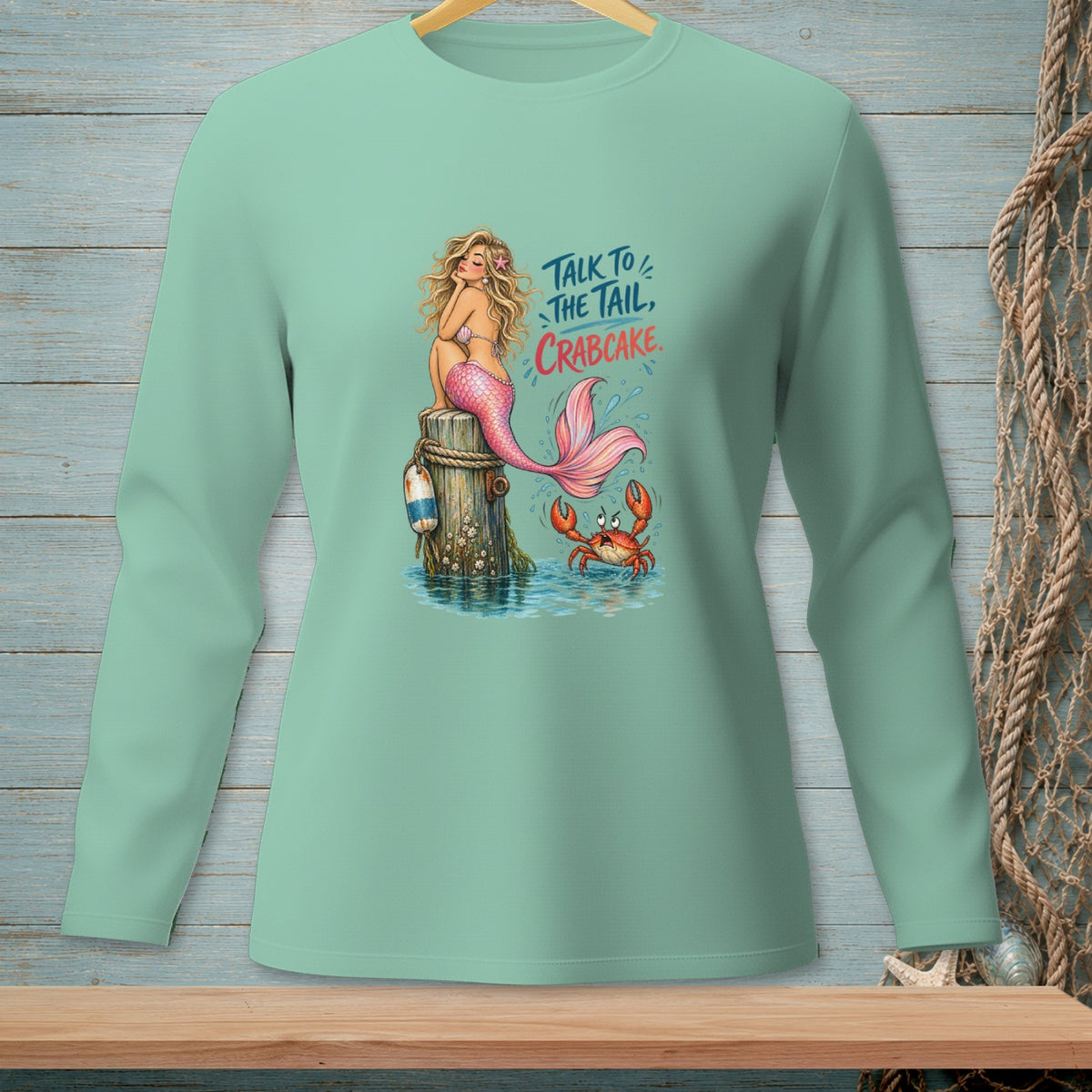 Mint green long-sleeve shirt with a mermaid and crab graphic saying "Talk to the tail, crabcake."