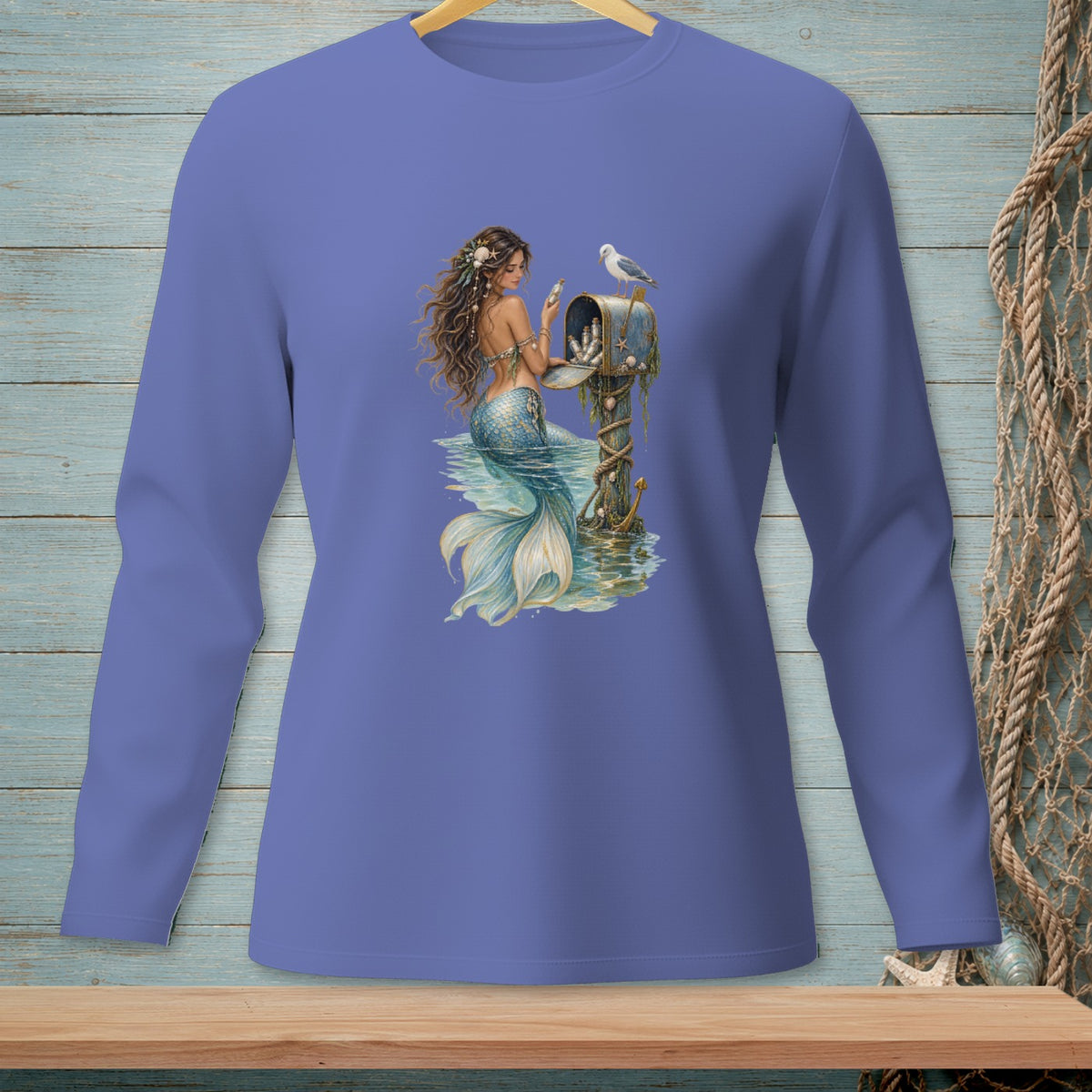 Mermaid sitting by a mailbox with a seagull and shells, on a blue background.