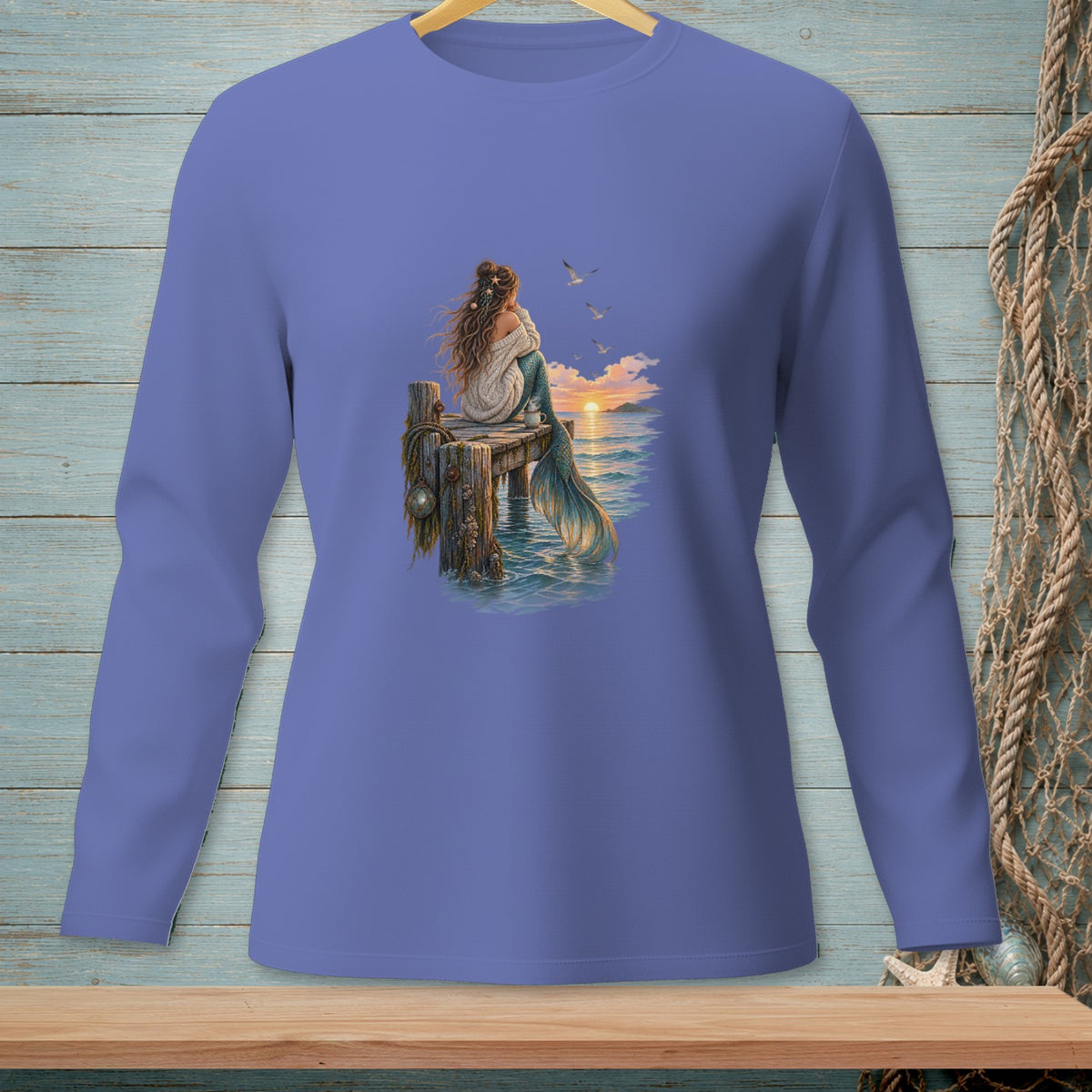 Purple long-sleeve shirt featuring a mermaid sitting on a dock at sunset.