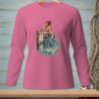 Pink long-sleeve shirt with a mermaid graphic resting on a pier railing.