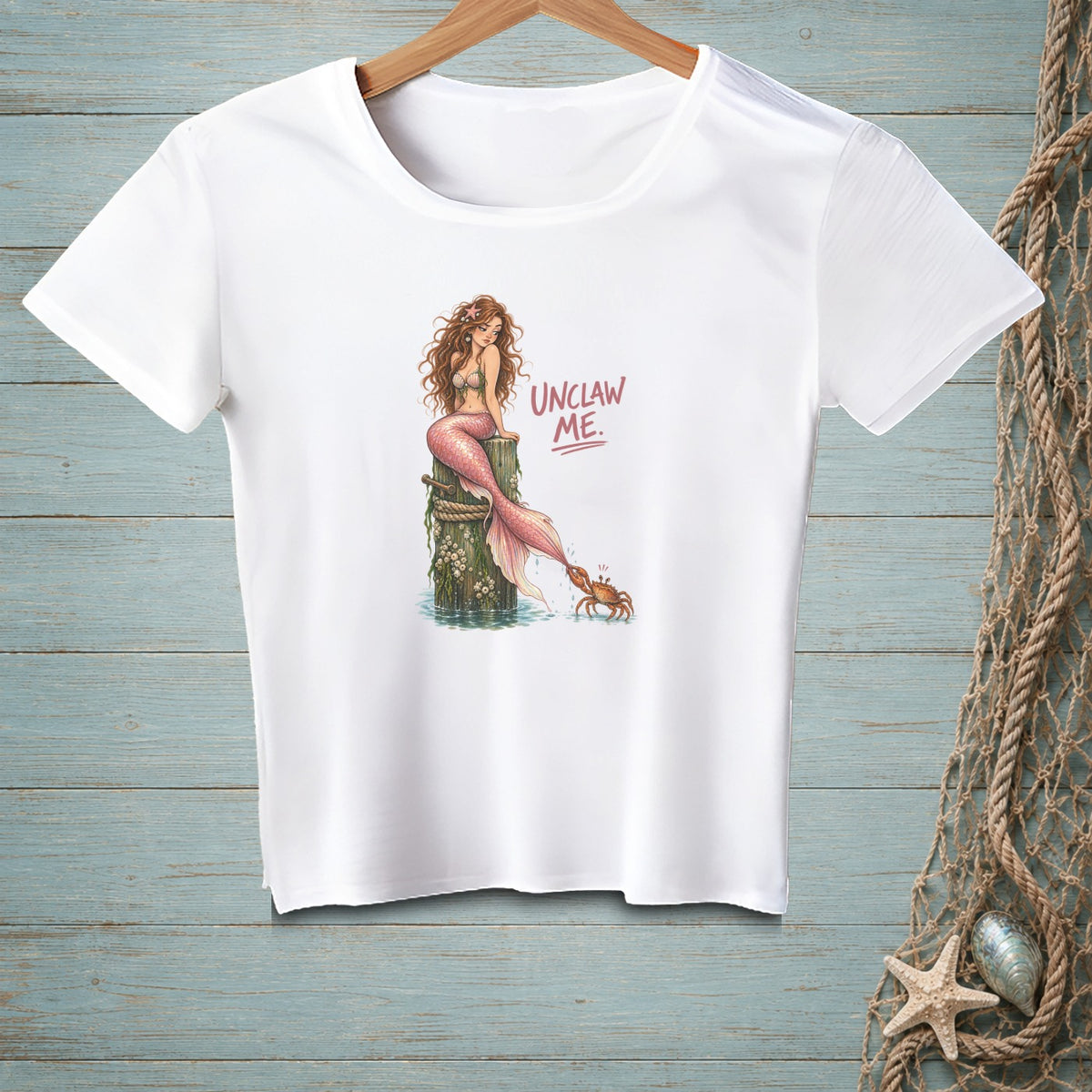 White t-shirt with a mermaid and crab graphic and "Unclaw Me" text.