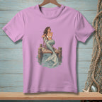 Illustration of a mermaid sitting on a chair on a dock, with her tail in the water.
