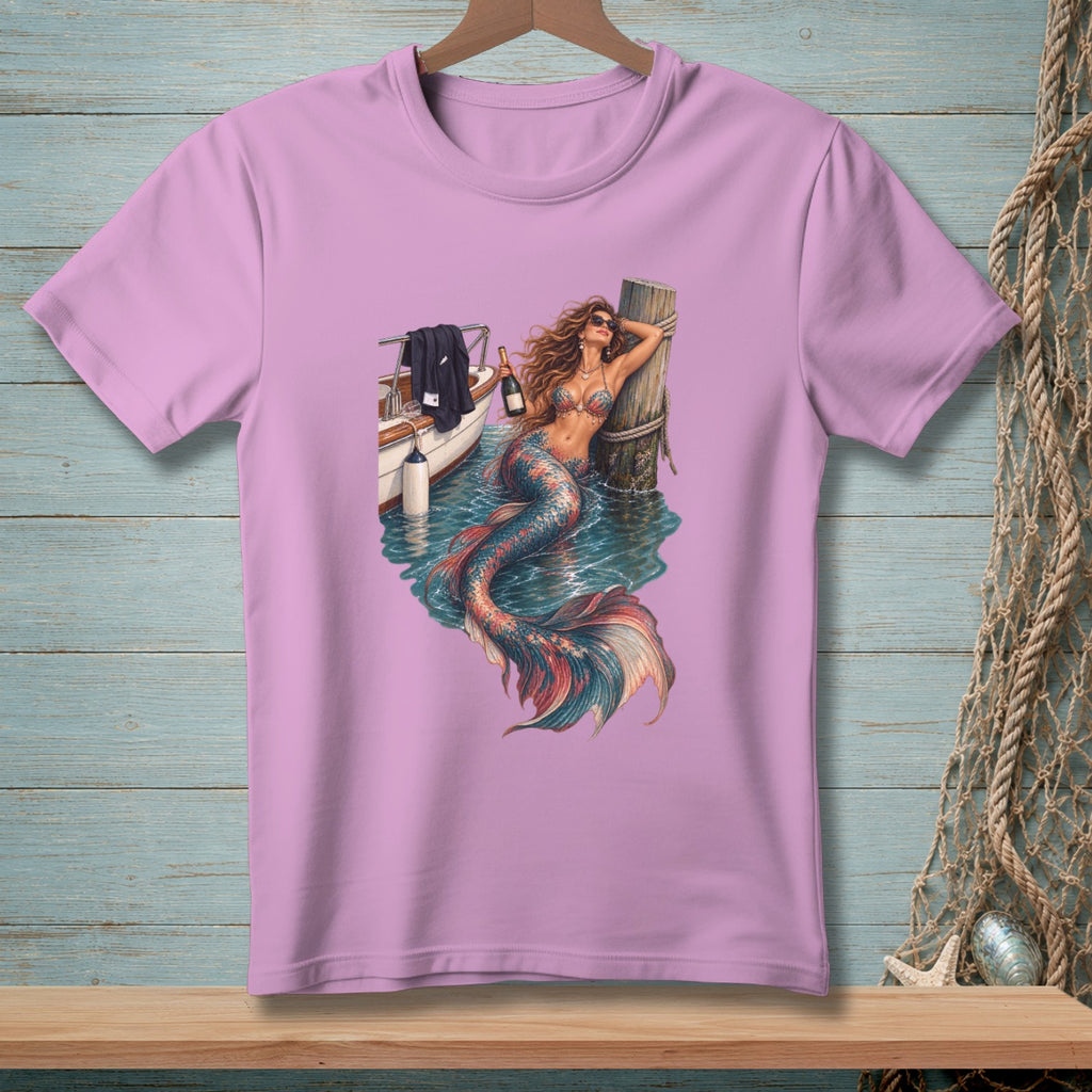 Pink t-shirt with mermaid leaning on a post next to a boat and bottle.