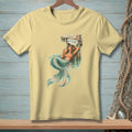 Yellow t-shirt with a graphic of a mermaid lounging by a sign that reads "ATTITUDE".