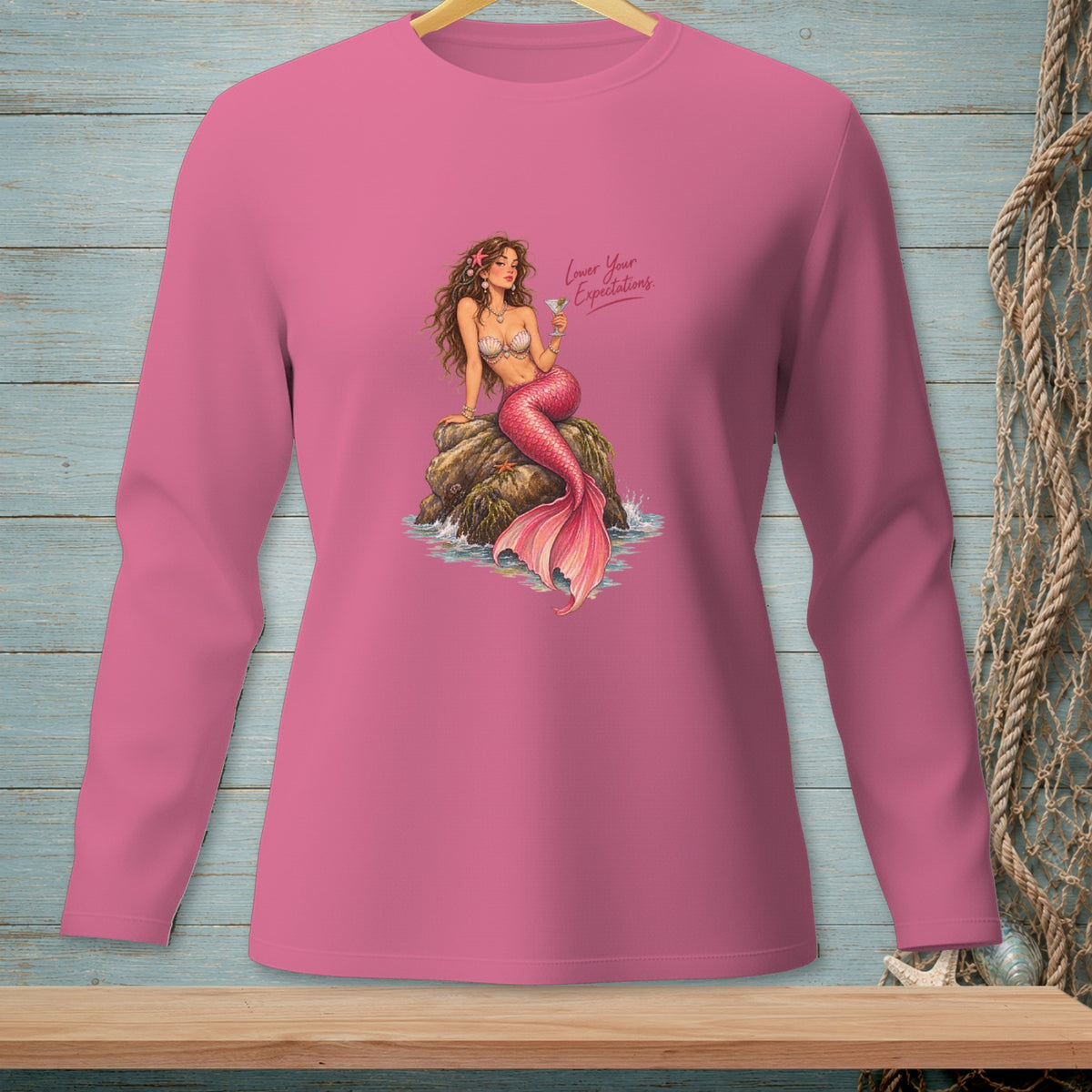 Pink shirt with mermaid graphic and text "Lower Your Expectations."