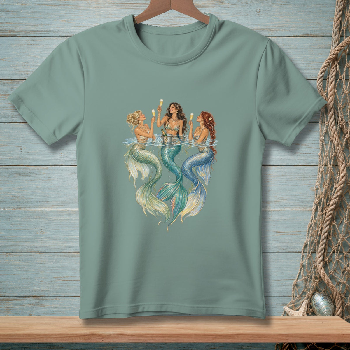 Three mermaids with colorful tails drink from champagne flutes in the water.