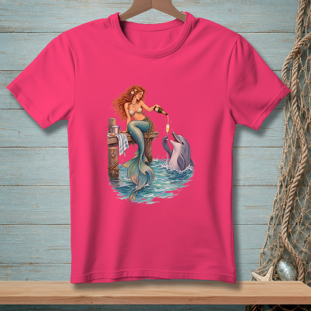Mermaid pours champagne for a dolphin on a wooden pier.