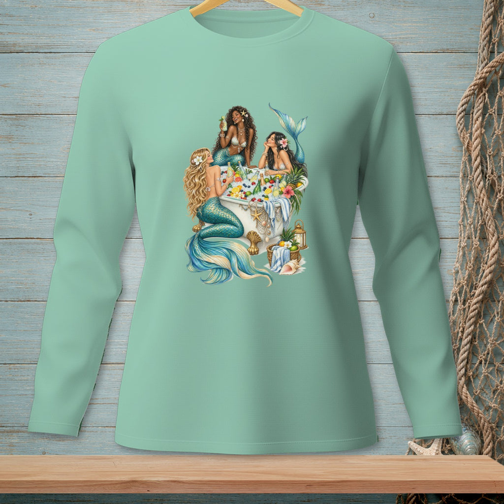 Three mermaids relax in a bathtub filled with fruit and drinks, with floral accents.