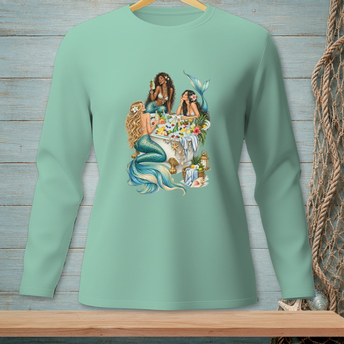 Three mermaids relax in a bathtub filled with fruit and drinks, with floral accents.