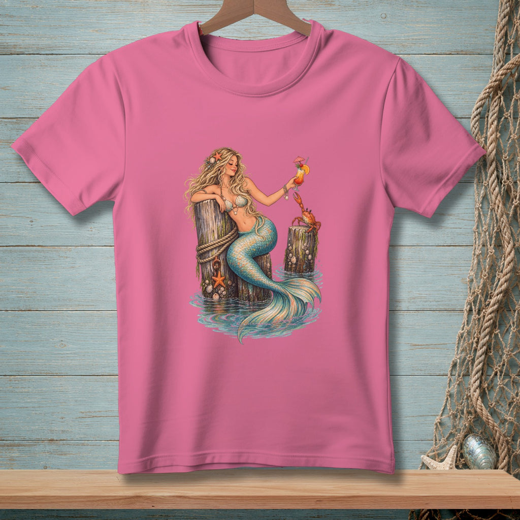 Mermaid with a drink and a crab sitting on wooden posts in water.