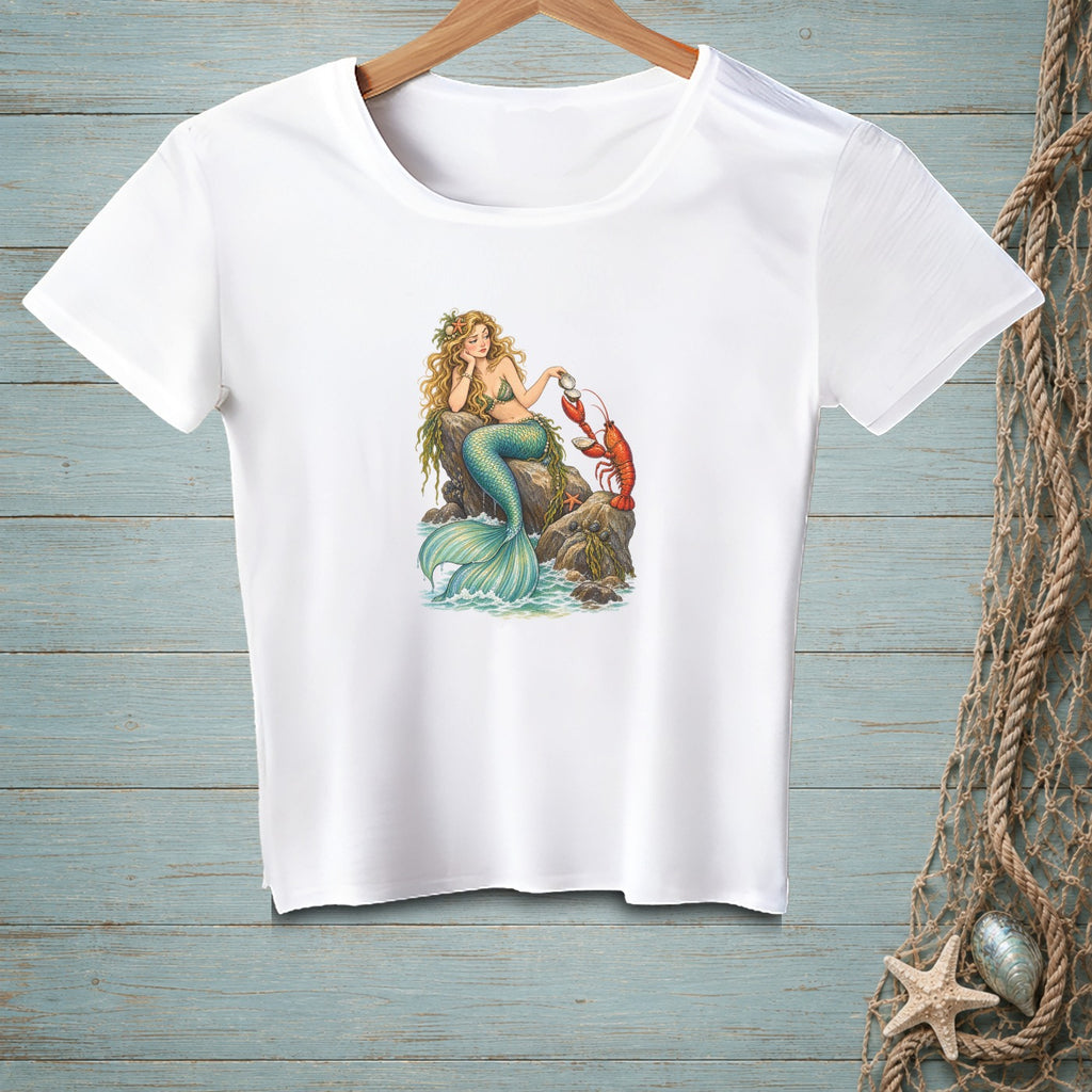 White t-shirt with a graphic of a mermaid and lobster by the sea.