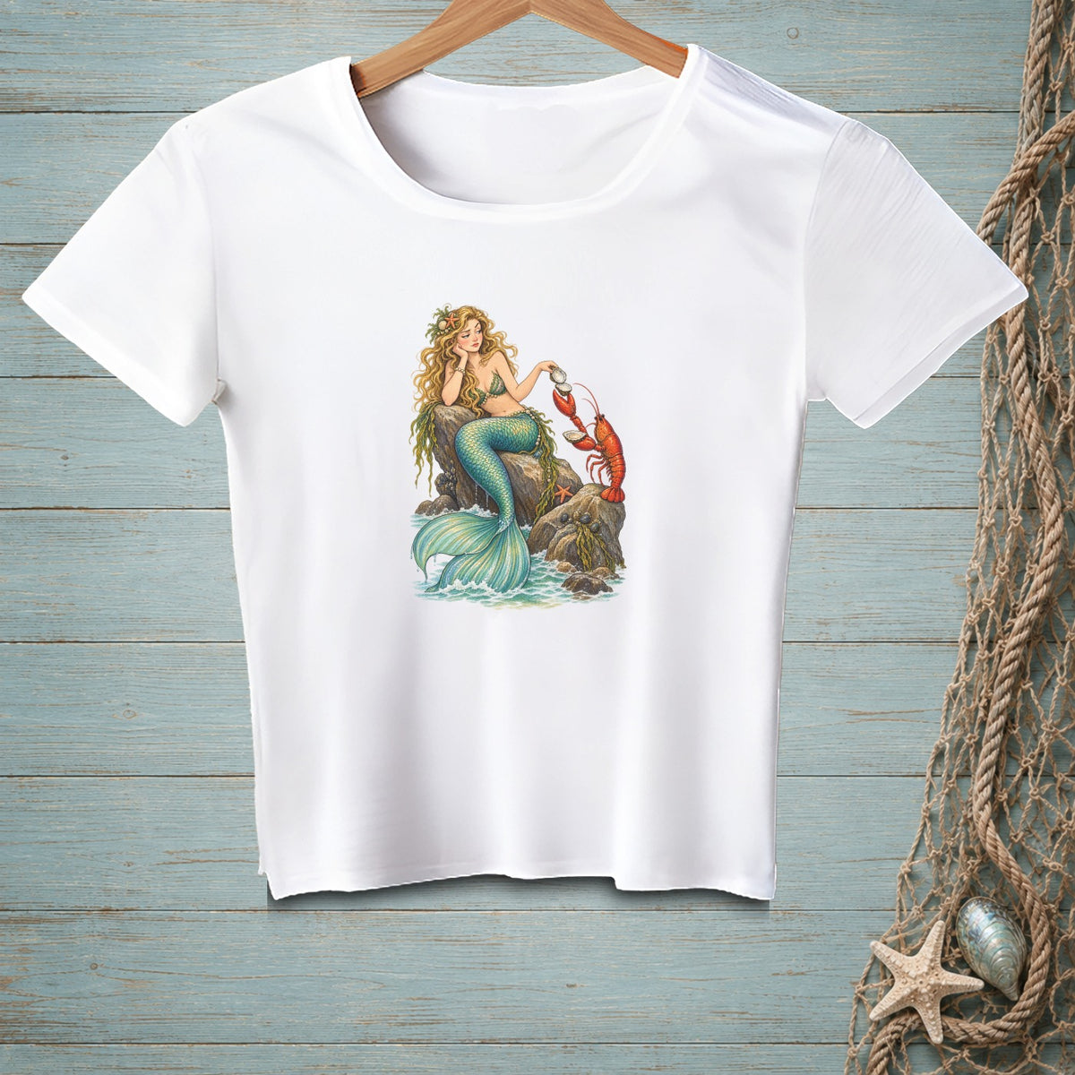 White t-shirt with a graphic of a mermaid and lobster by the sea.