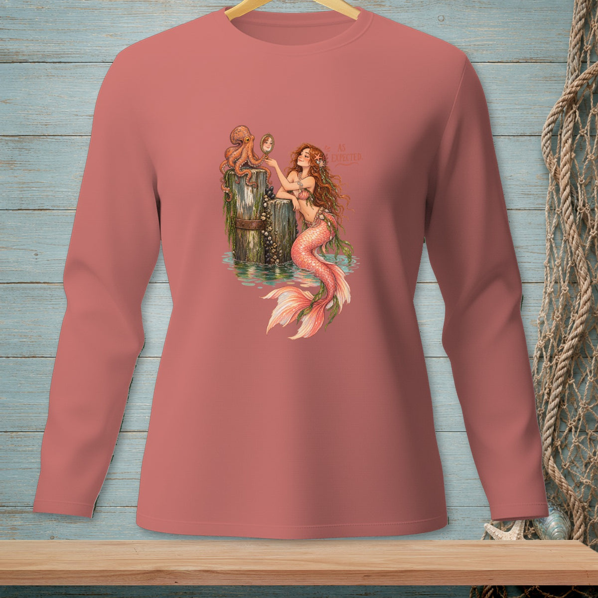 Mermaid with octopus looking in mirror, text "AS EXPECTED" on coral long sleeve shirt.