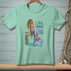 Mermaid with champagne and text "SEA HAIR ZERO CARE" on light teal t-shirt.