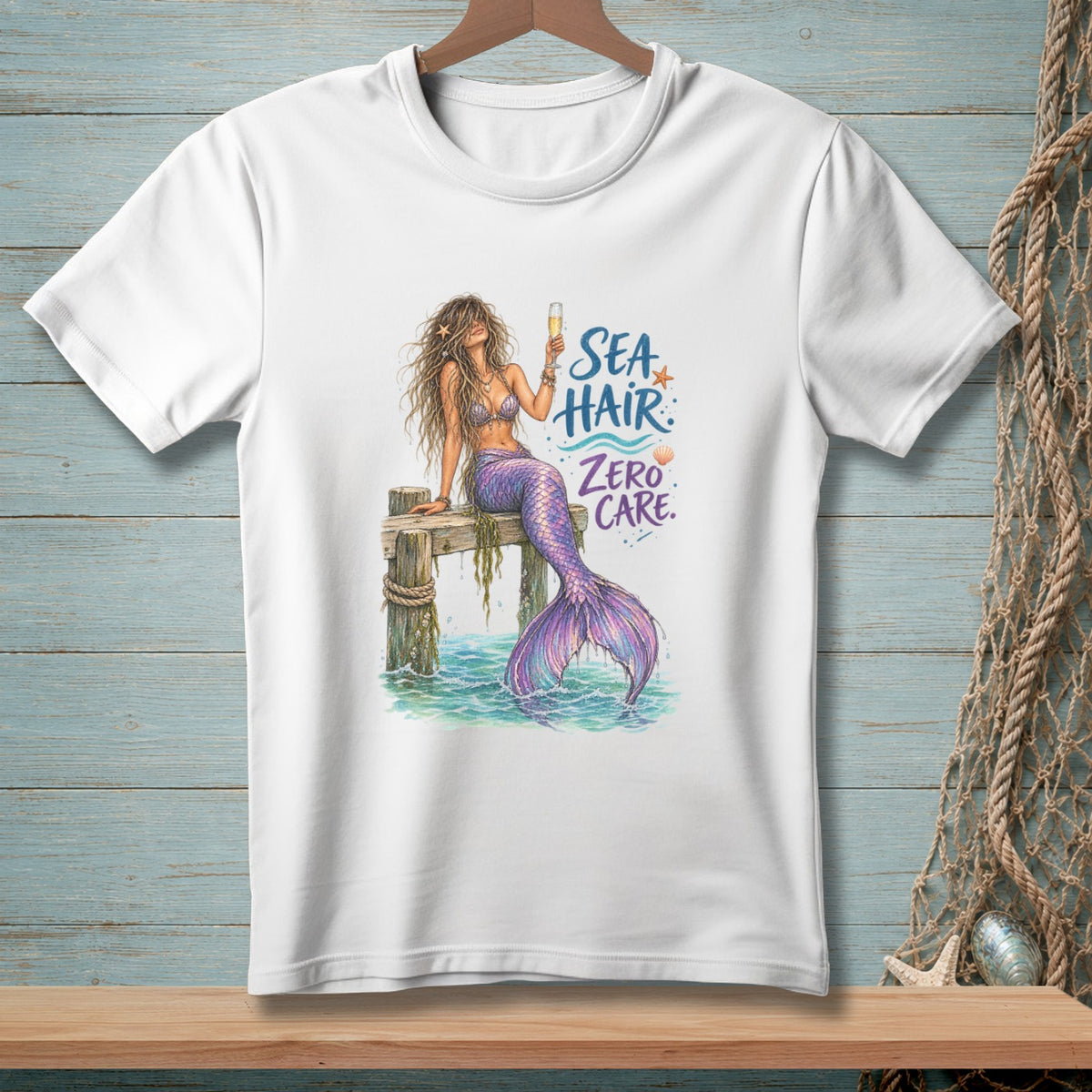 White t-shirt with mermaid illustration and text "Sea Hair Zero Care".