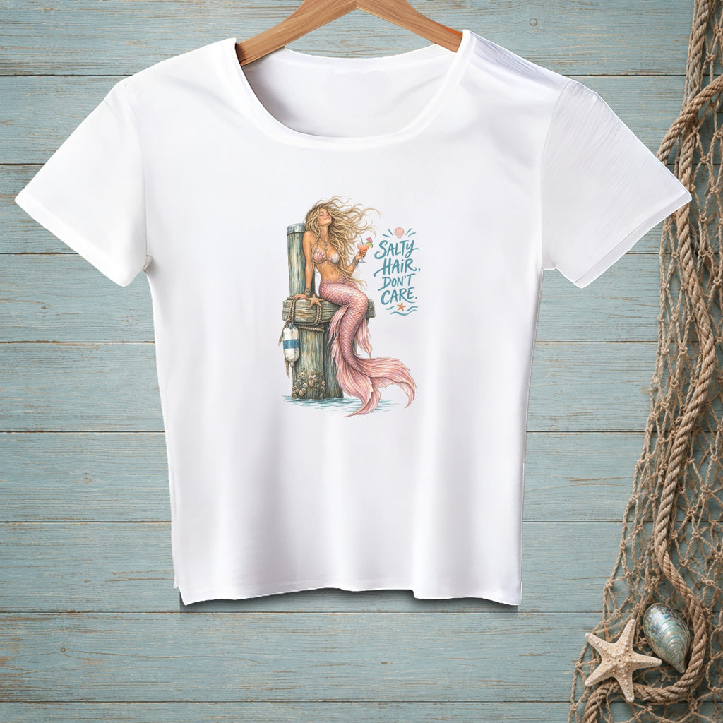White t-shirt with a mermaid illustration and text reading "Salty hair, don't care."