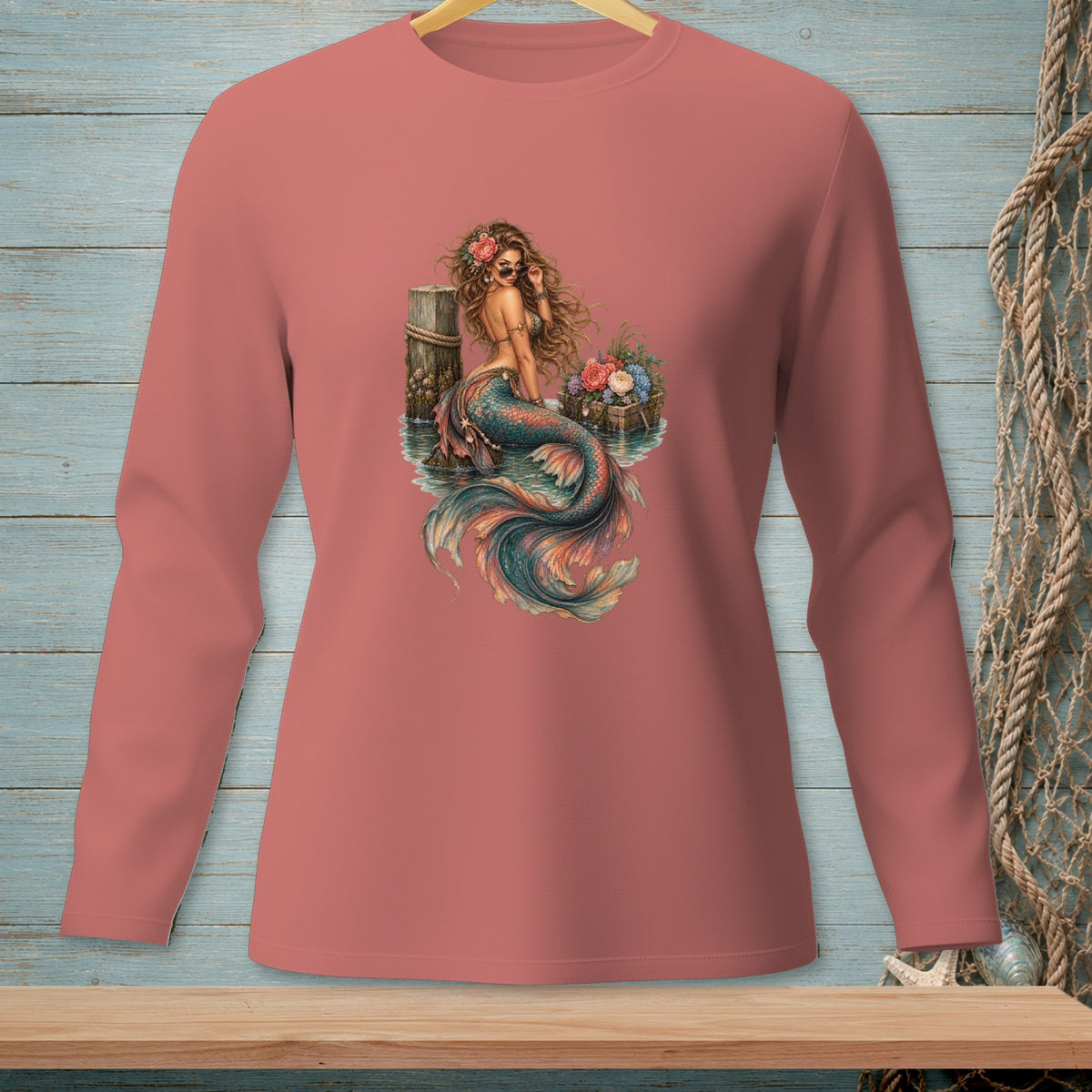 Mermaid with flowers and sunglasses sitting on a pier.