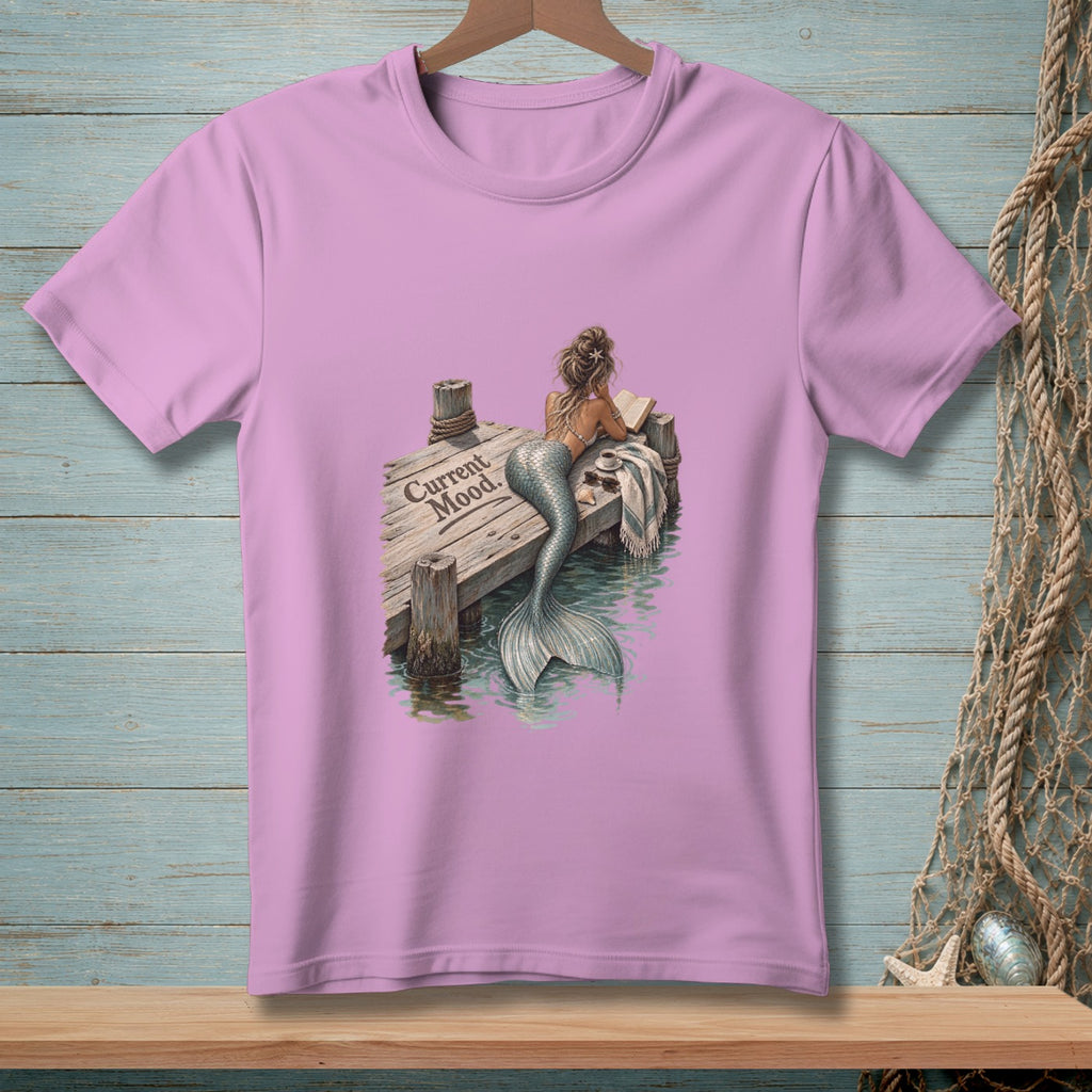 Pink t-shirt with mermaid reading on a dock, text reads "Current Mood."