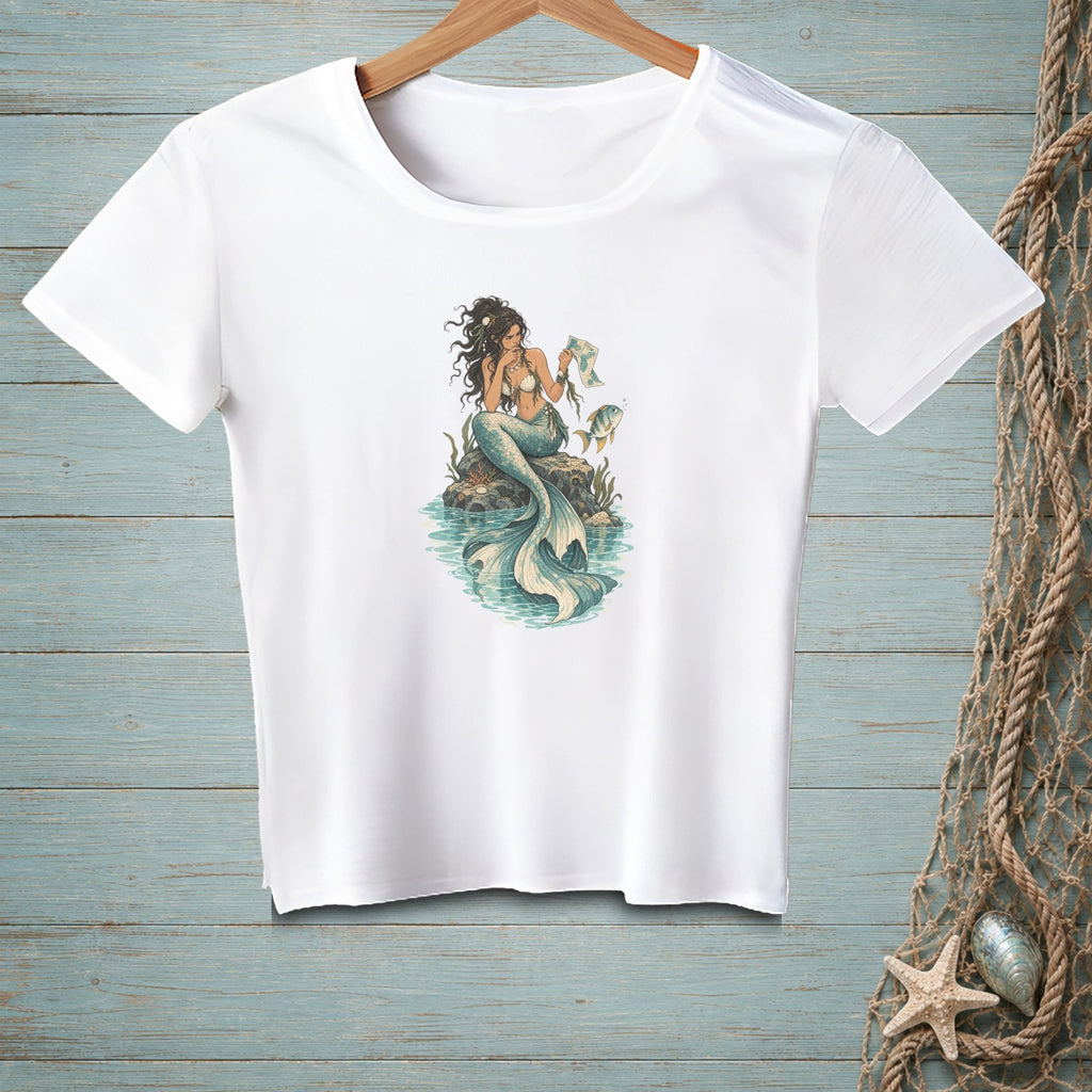 White t-shirt with a graphic of a mermaid sitting on a rock holding a seashell.