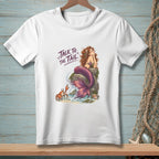 White t-shirt featuring a mermaid on a rock with a crab and the text "TALK TO THE TAIL".