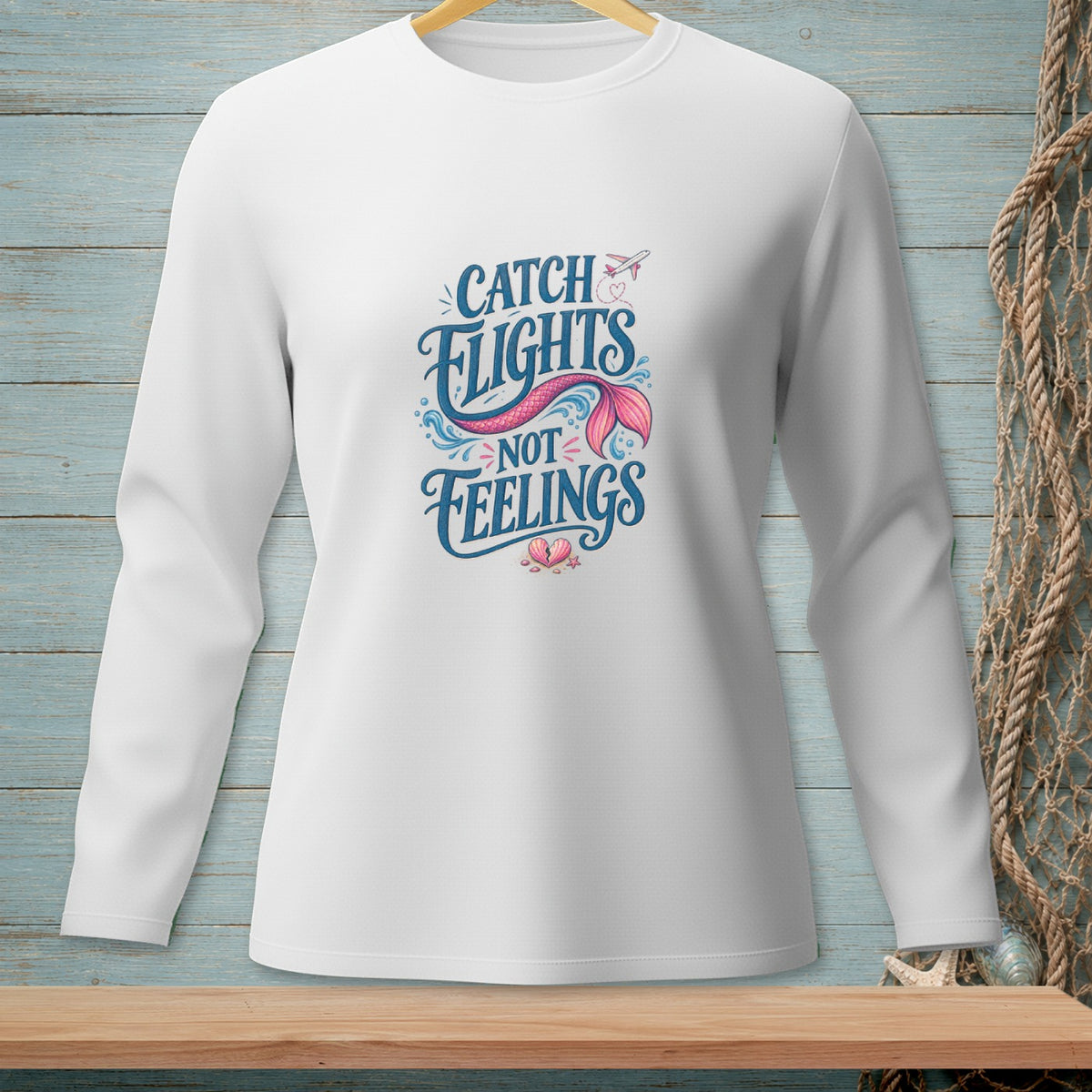 White long-sleeve shirt with "Catch Flights Not Feelings" mermaid tail graphic.