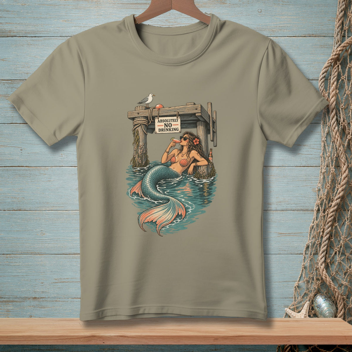 T-shirt with a mermaid sitting by a pier with a "Absolutely No Drinking" sign.