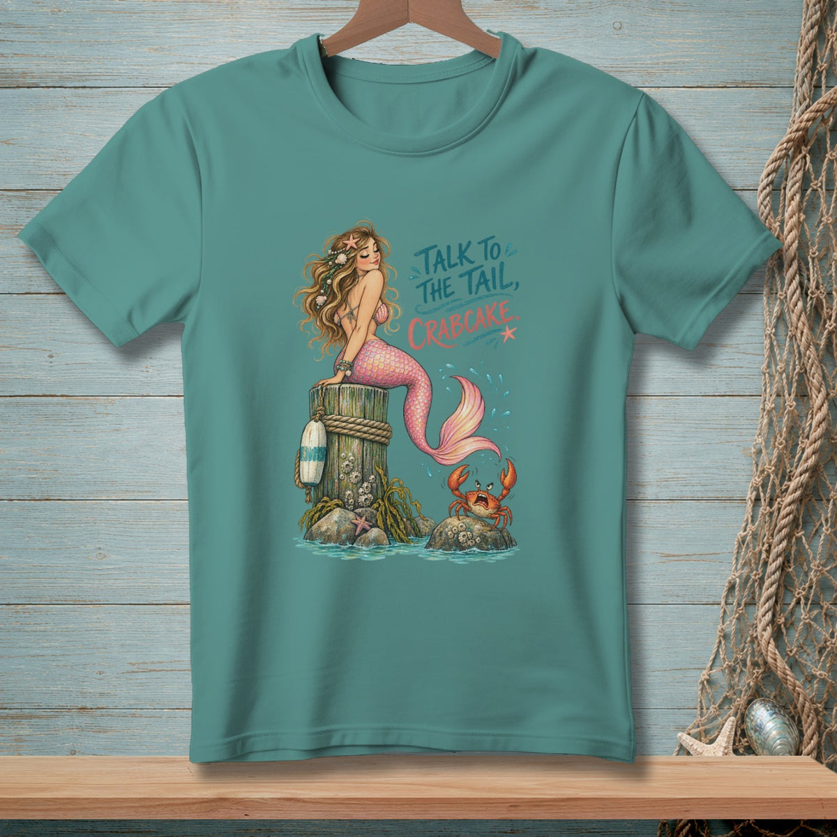 Mermaid on a post with crab and text "Talk to the tail, crabcake".