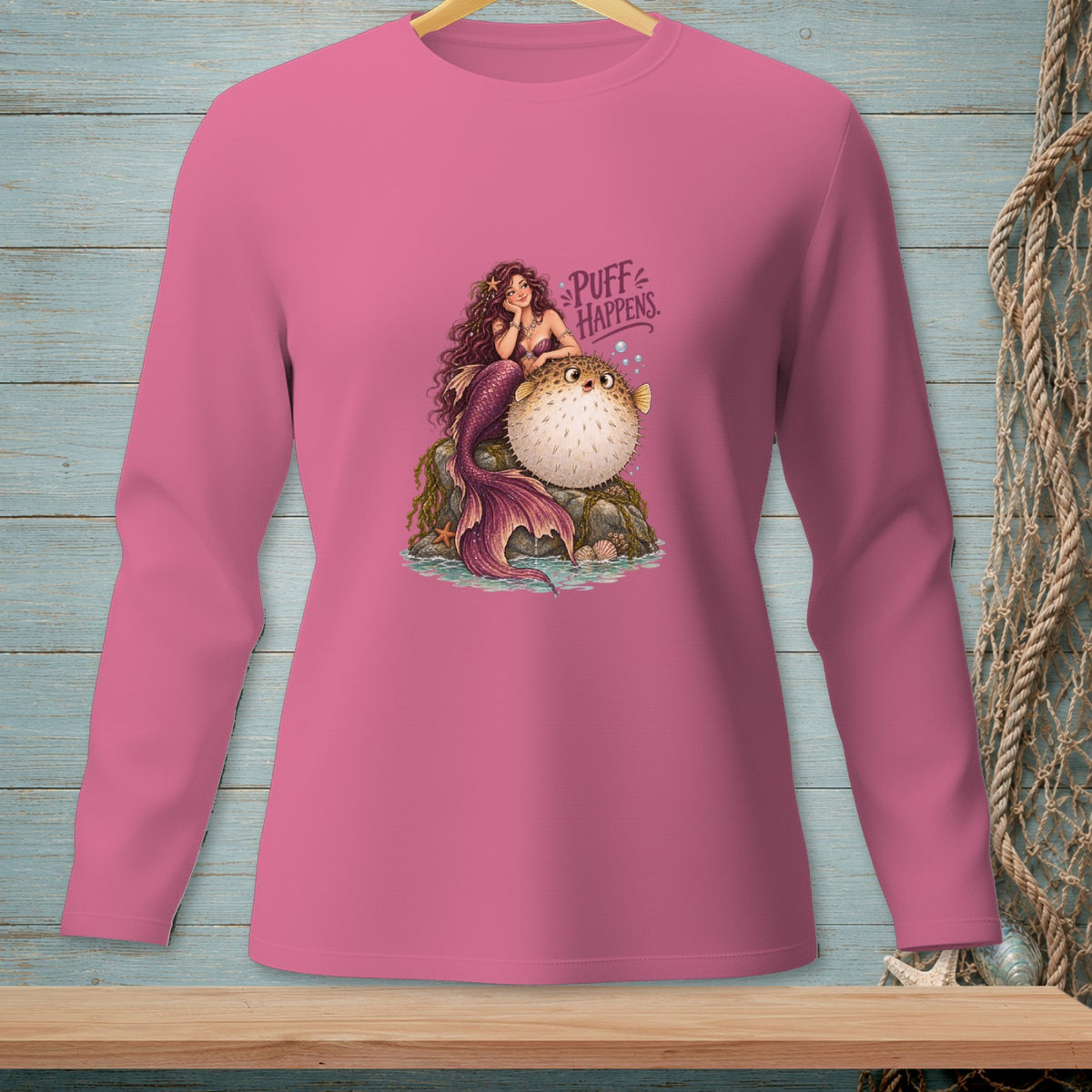 Pink long-sleeve shirt with a mermaid and pufferfish graphic that says "Puff Happens."
