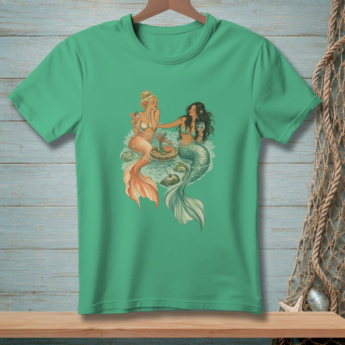 Two mermaids holding drinks relax by a small floating table.