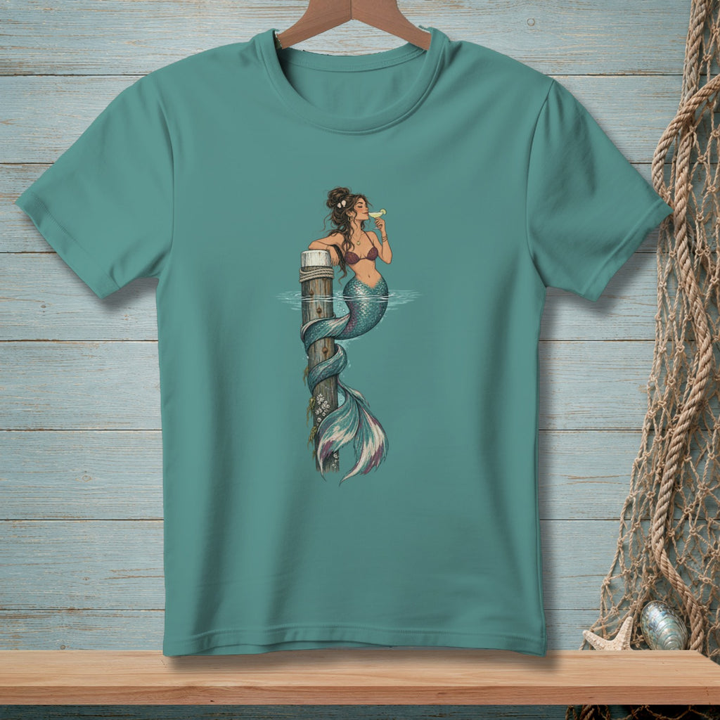 Mermaid with cocktail wrapped around wooden post in teal t-shirt graphic.