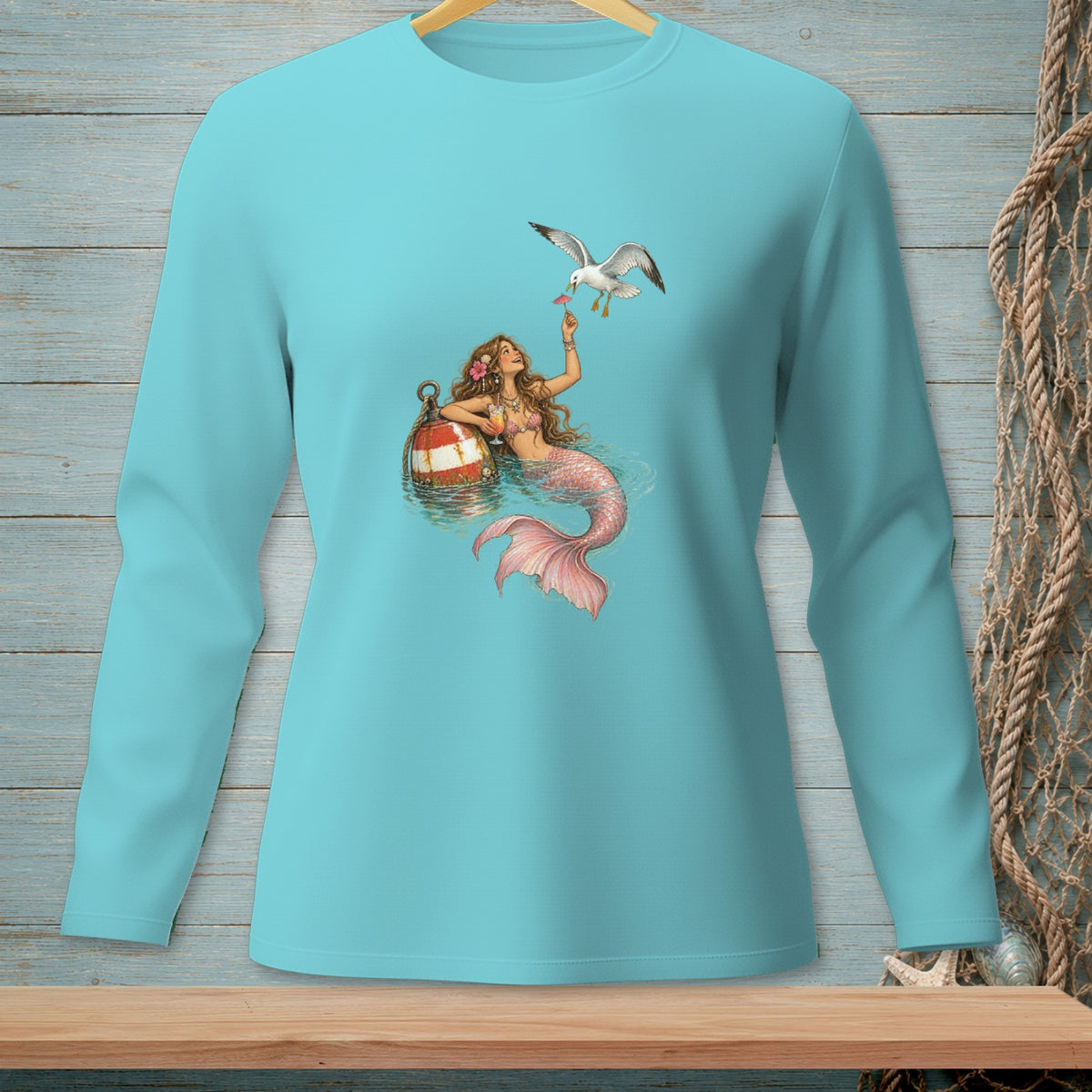 Teal long-sleeve shirt with a mermaid and seagull graphic.