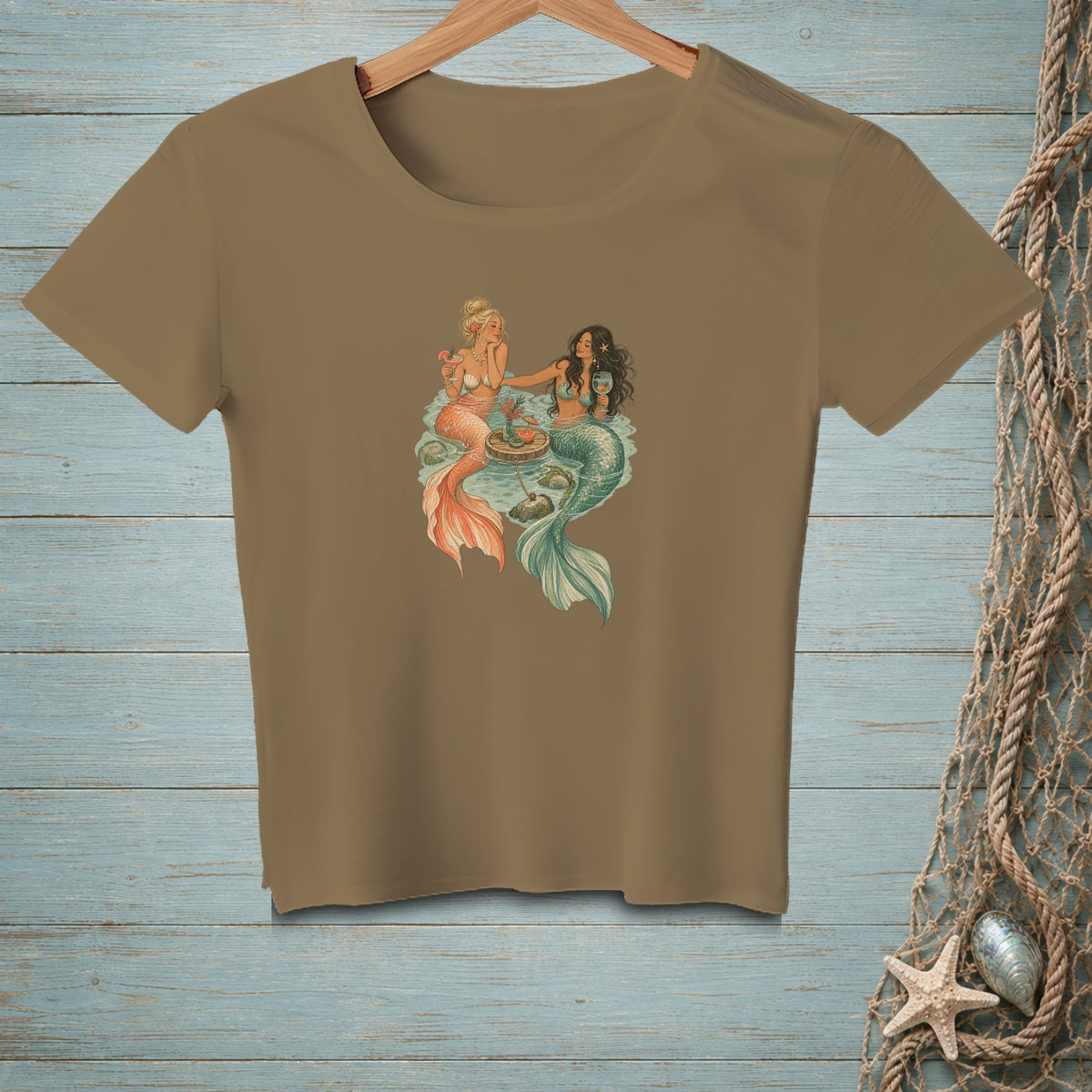 Two mermaids sharing drinks and food on a round table.