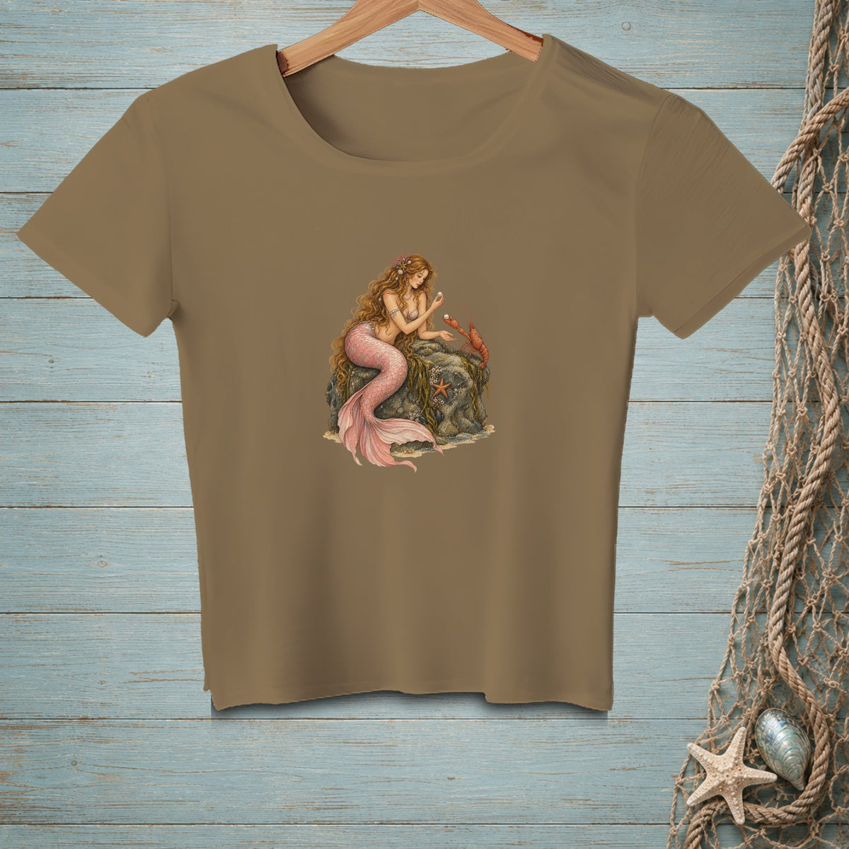 T-shirt with a mermaid and crab illustration on a rock with seaweed.