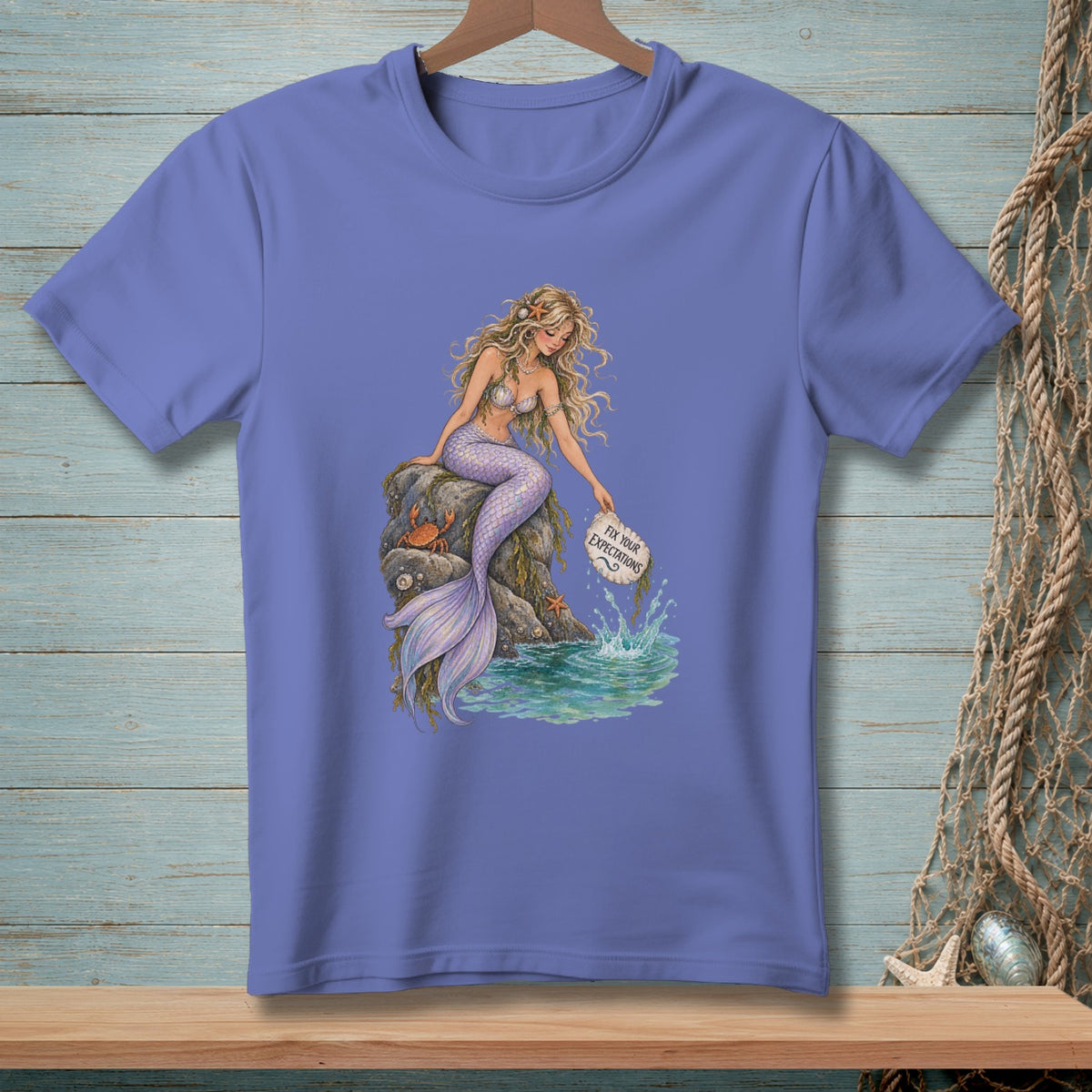 Mermaid sitting on a rock, dropping sign that says "Fix Your Expectations".