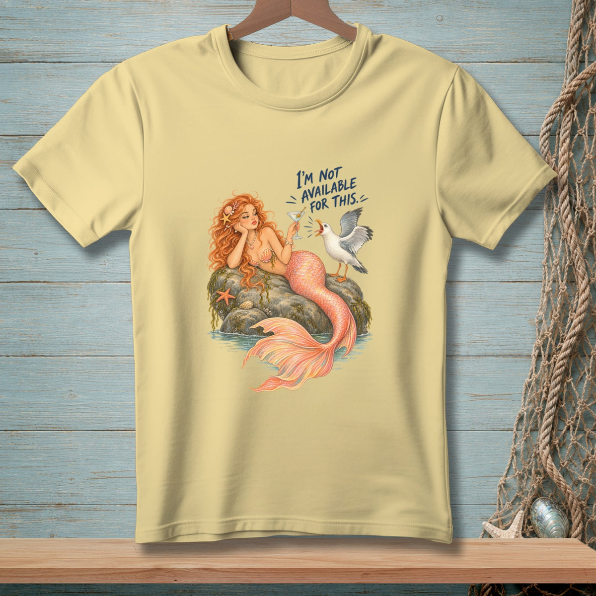 Yellow t-shirt with mermaid and seagull graphic that reads "I'm not available for this."
