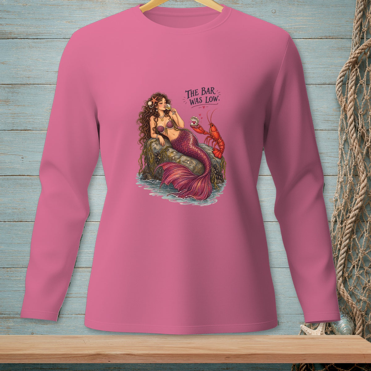 Mermaid with lobster and text "The Bar Was Low" on pink shirt.