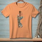 Peach t-shirt with a mermaid wrapped around a post, drinking a cocktail.