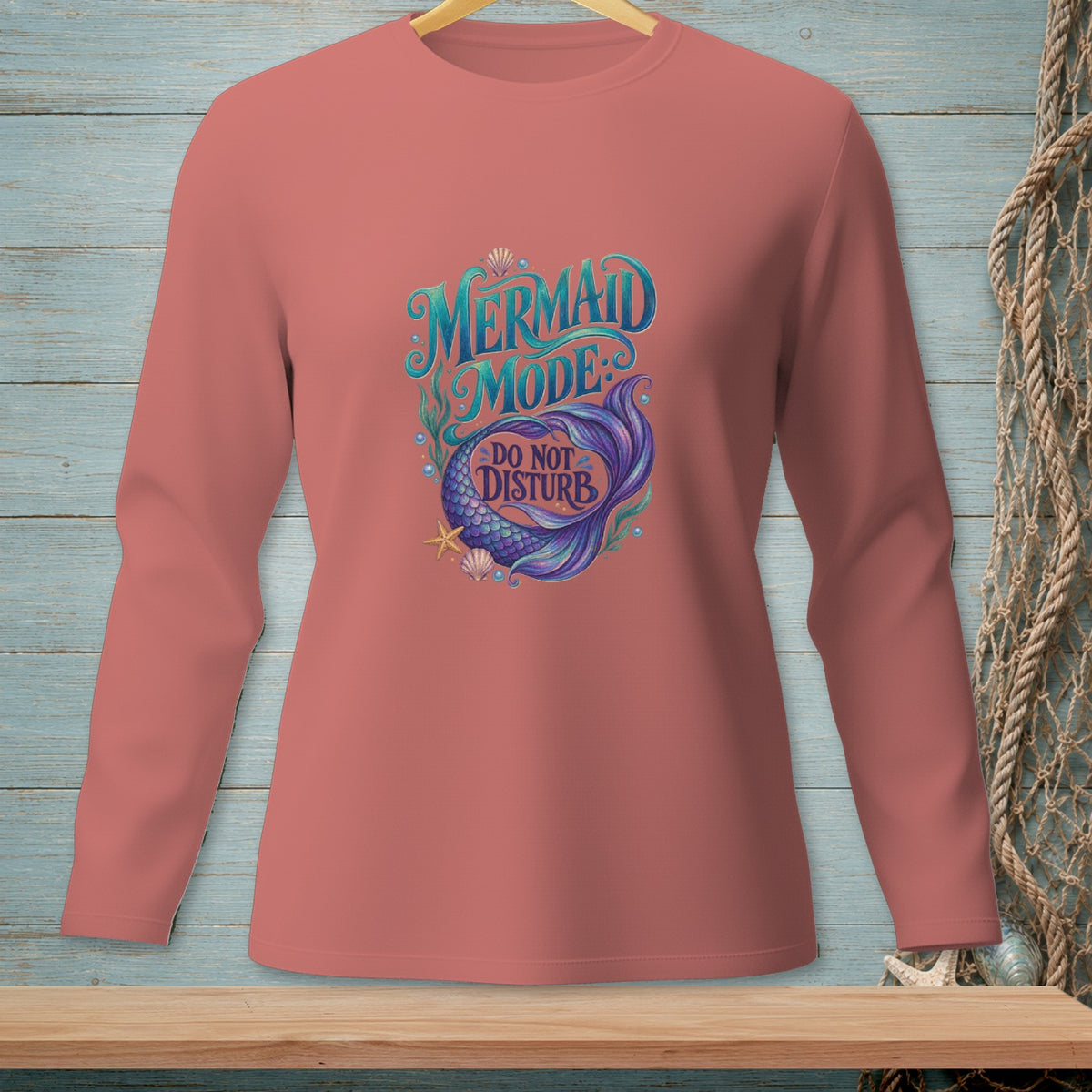 Long-sleeved coral shirt with "Mermaid Mode Do Not Disturb" text and mermaid tail graphic.