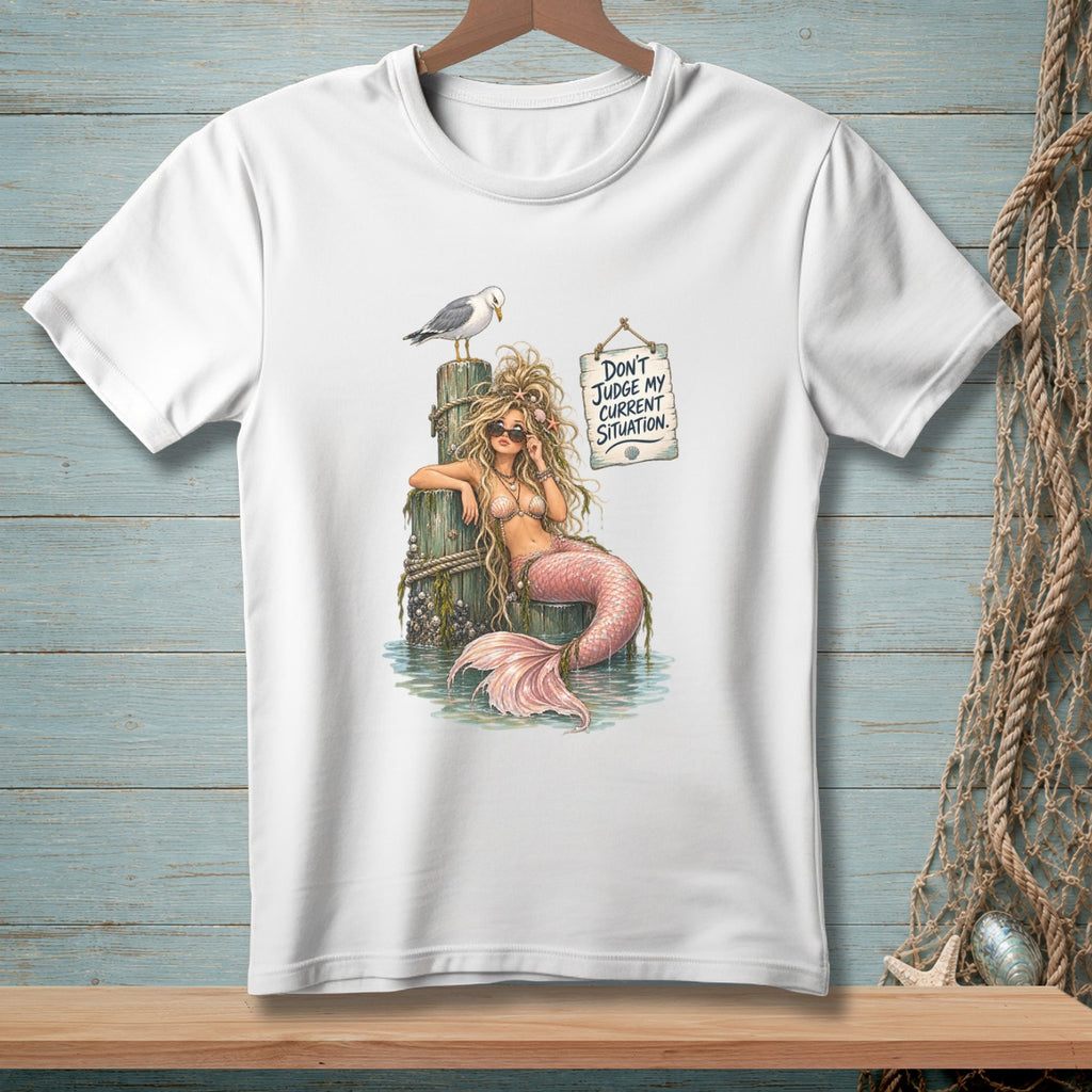 Mermaid on a post with a seagull and a sign reading "Don't judge my current situation."
