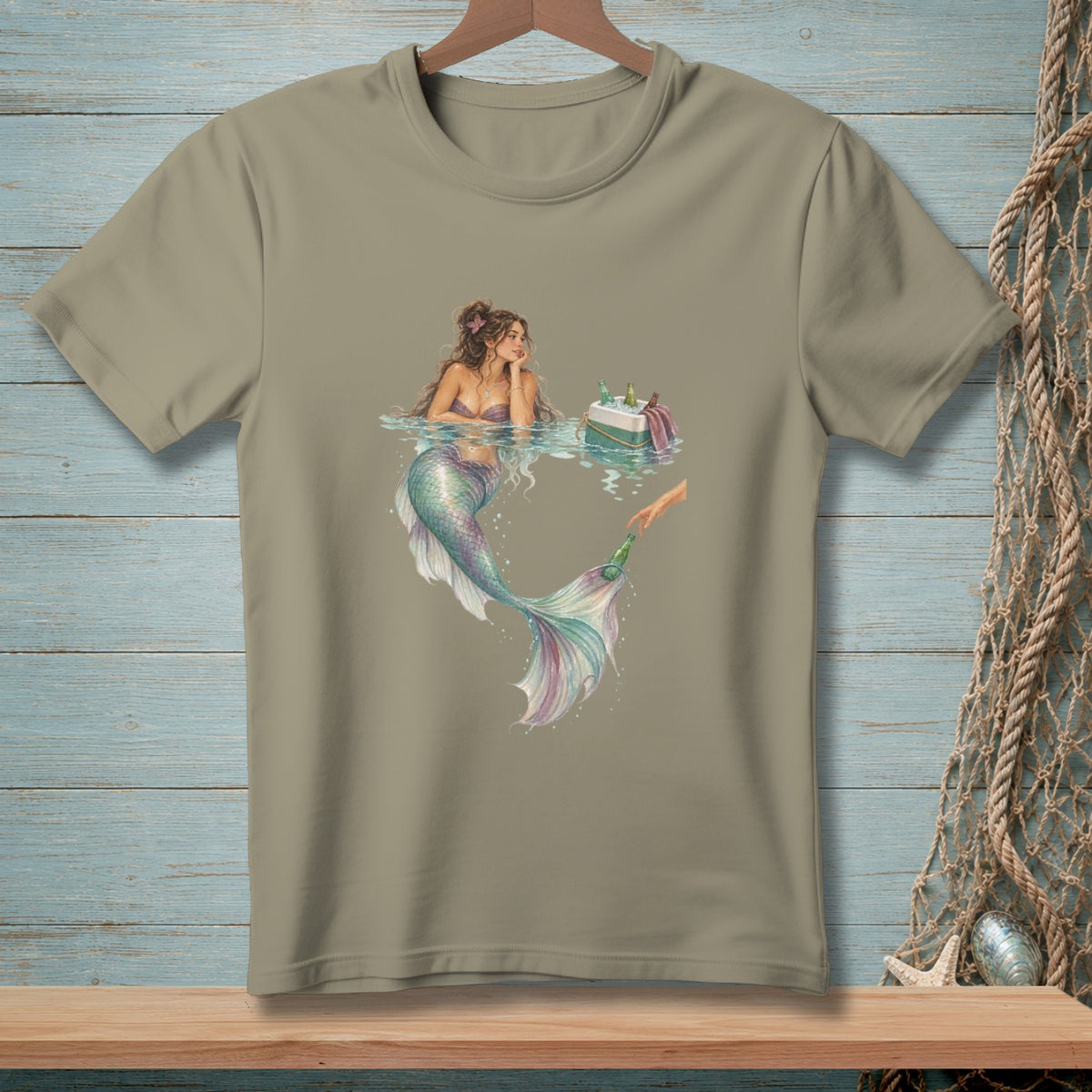 T-shirt with watercolor art of a mermaid reaching for a bottle from a cooler.