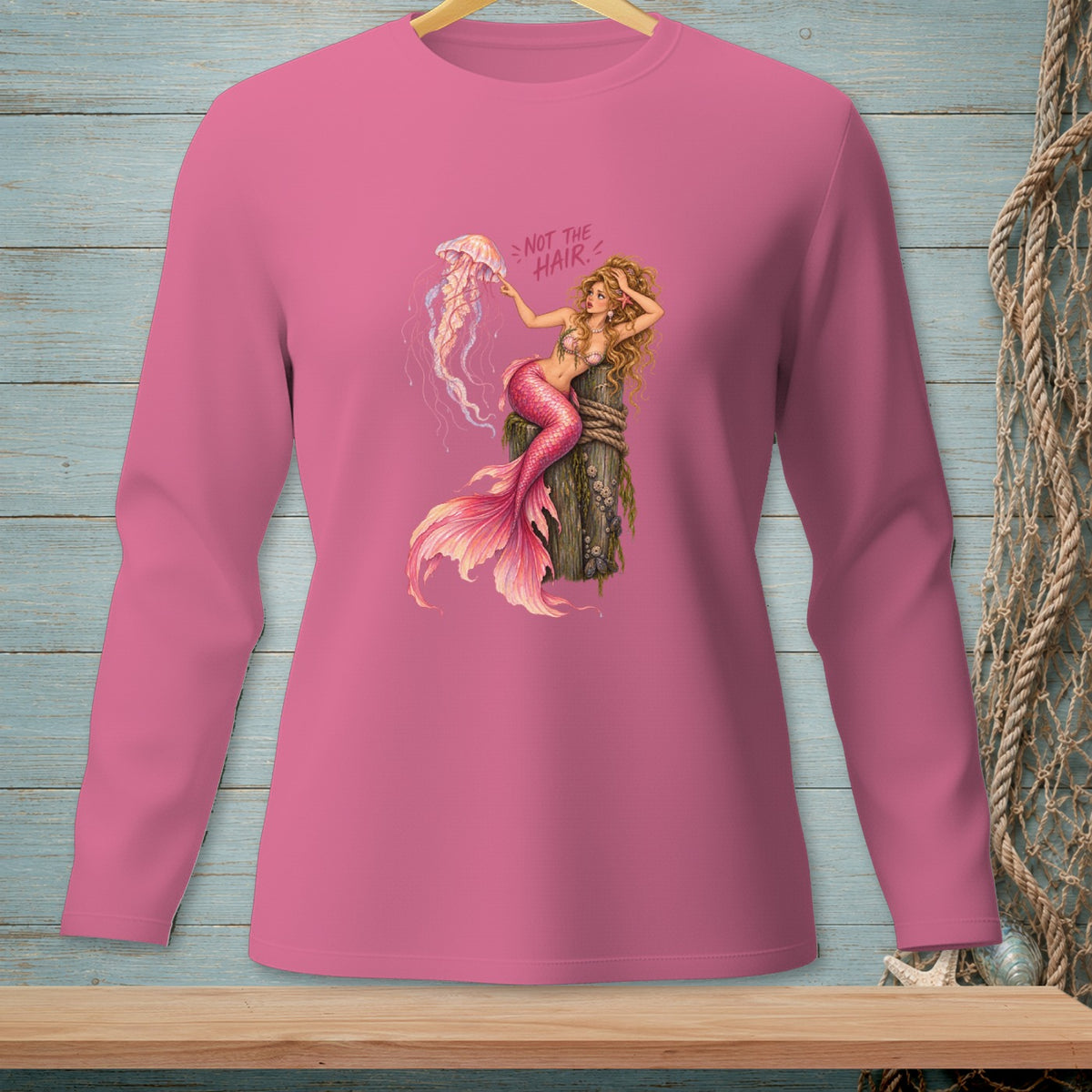 Pink long-sleeve shirt with a mermaid and jellyfish graphic and text.